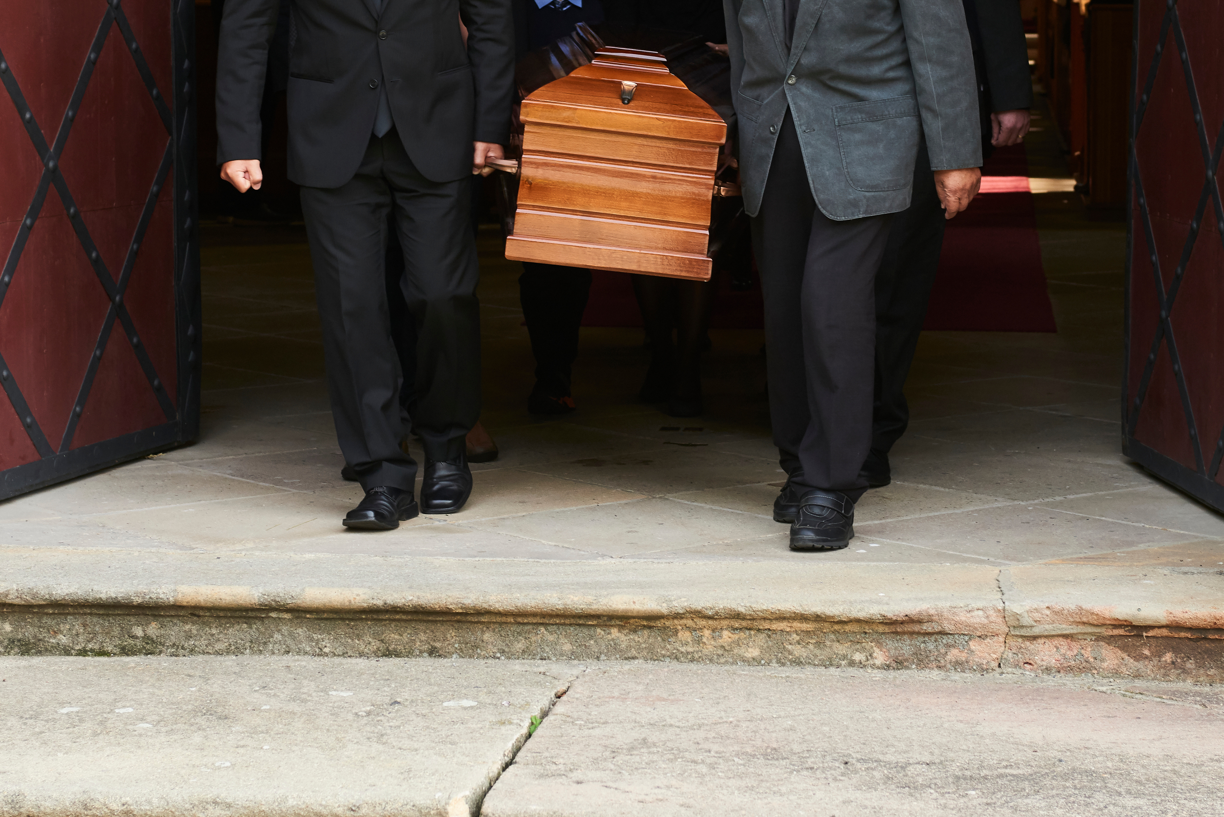 Group carries a coffin out of the church after a funeral mass