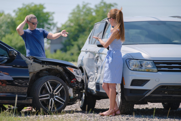 two frustrated people at a car accident scene